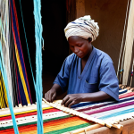 차드에서 유행하는 패션 스타일 - Traditional Textile Revival**

"A Chadian artisan working on a Kita cotton loom, surrounded by vibra...